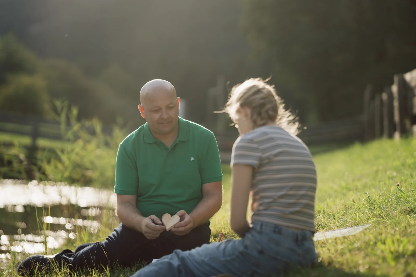 Zwei Personen sitzen im Freien bei einer angeleiteten Übung.